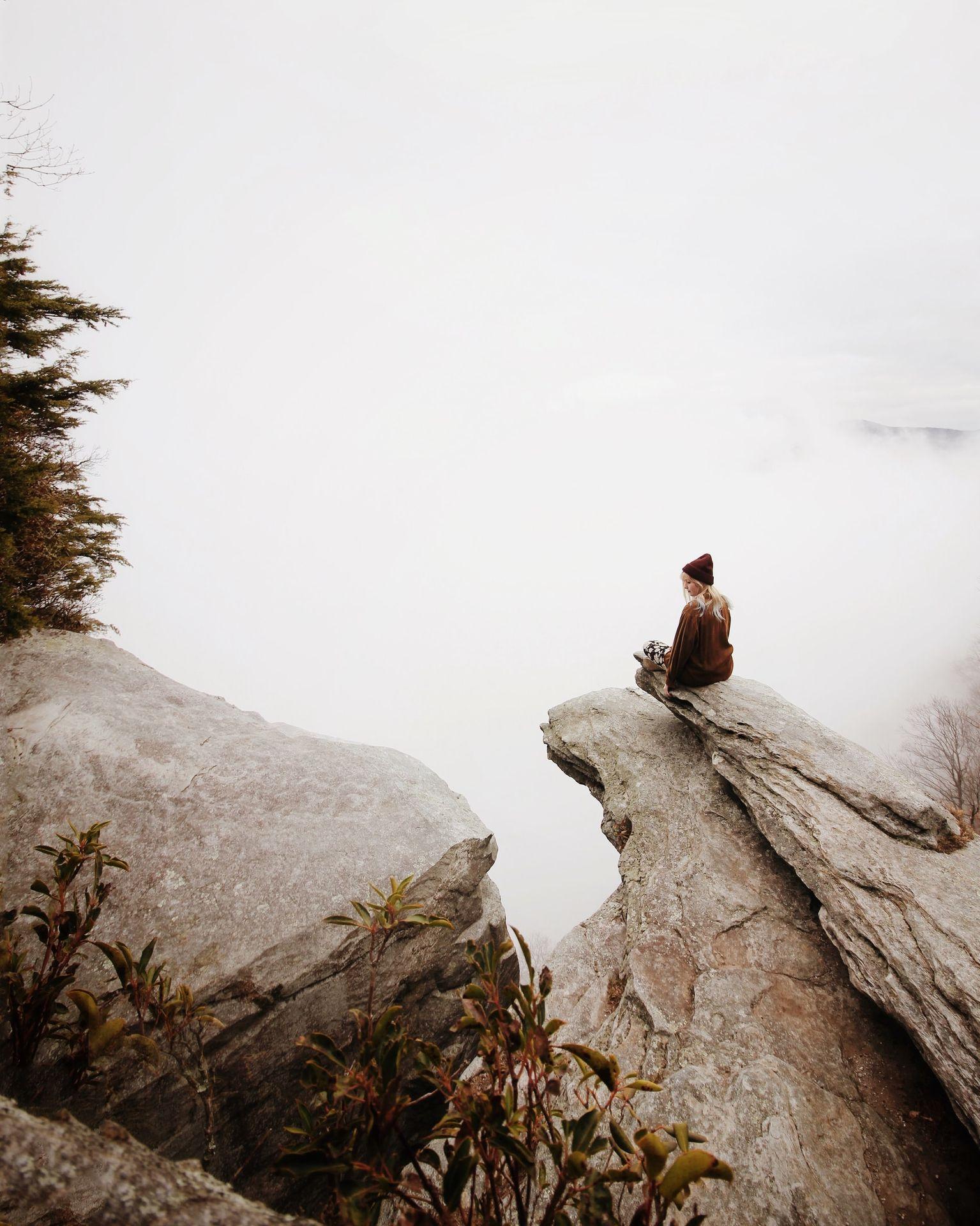 woman sitting on brown rock