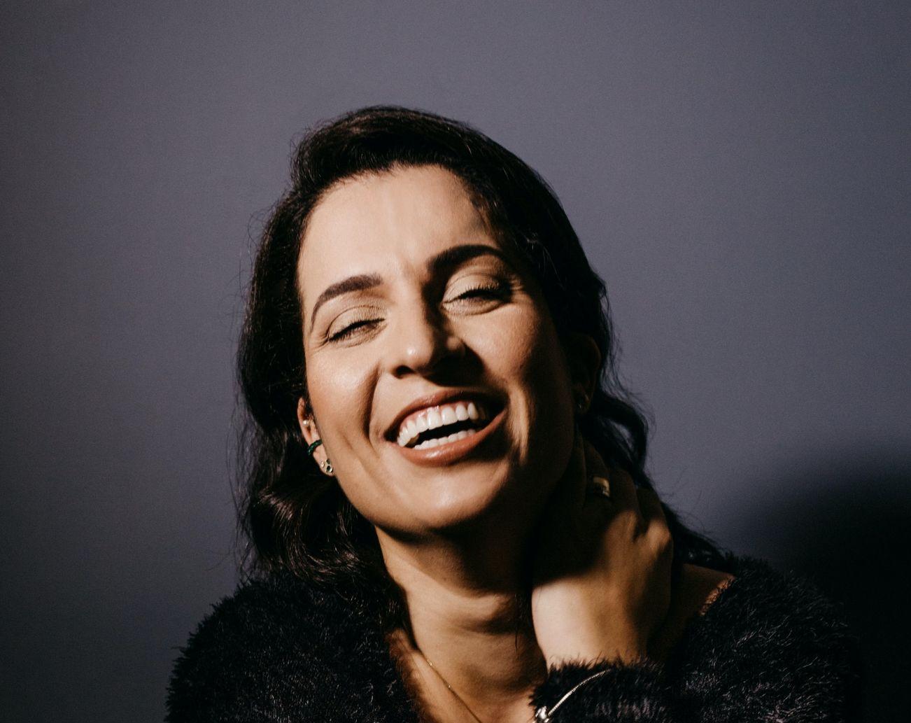 smiling woman in black fur coat