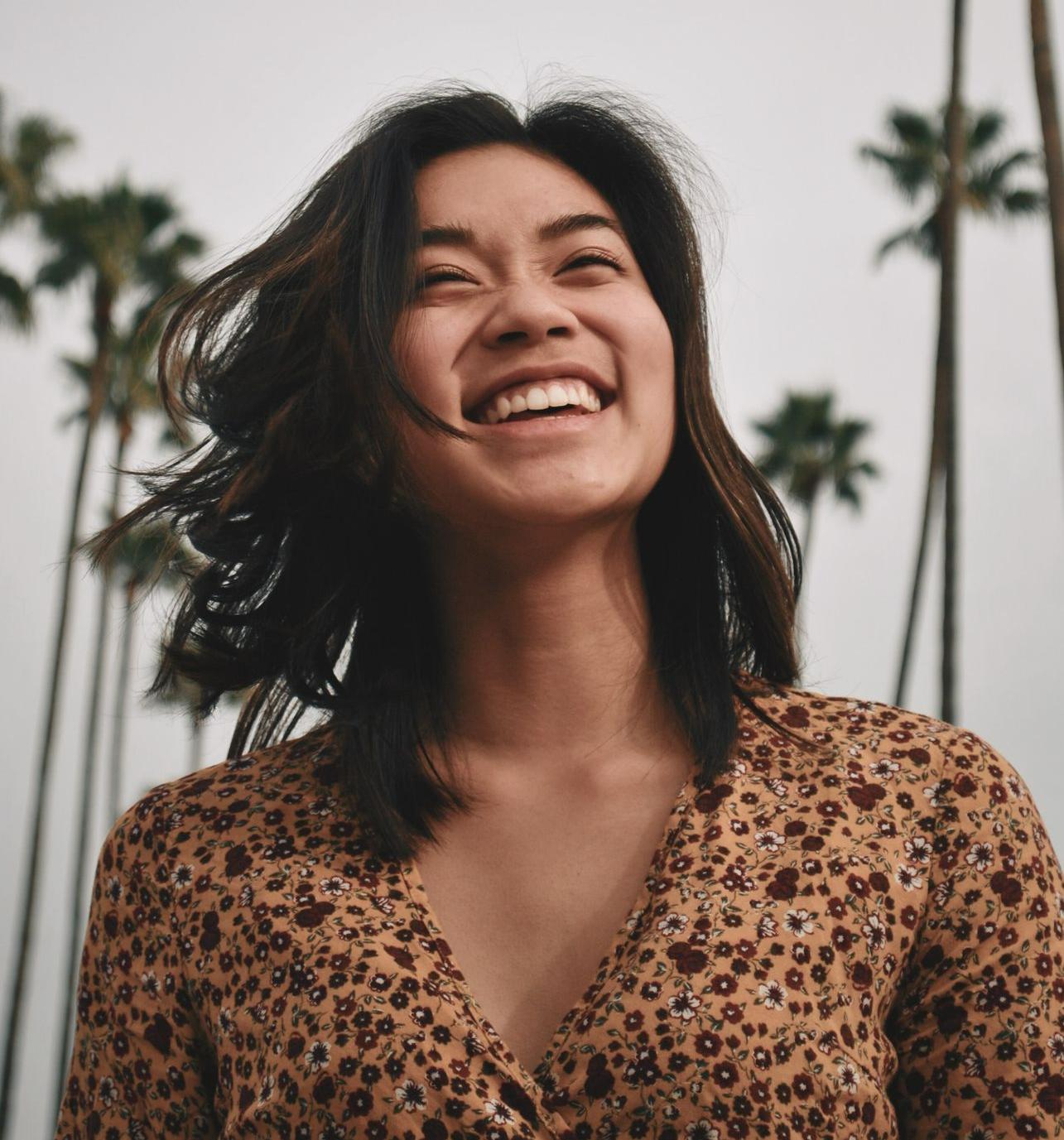 Loopbaancoach woman in brown floral dress standing and smiling