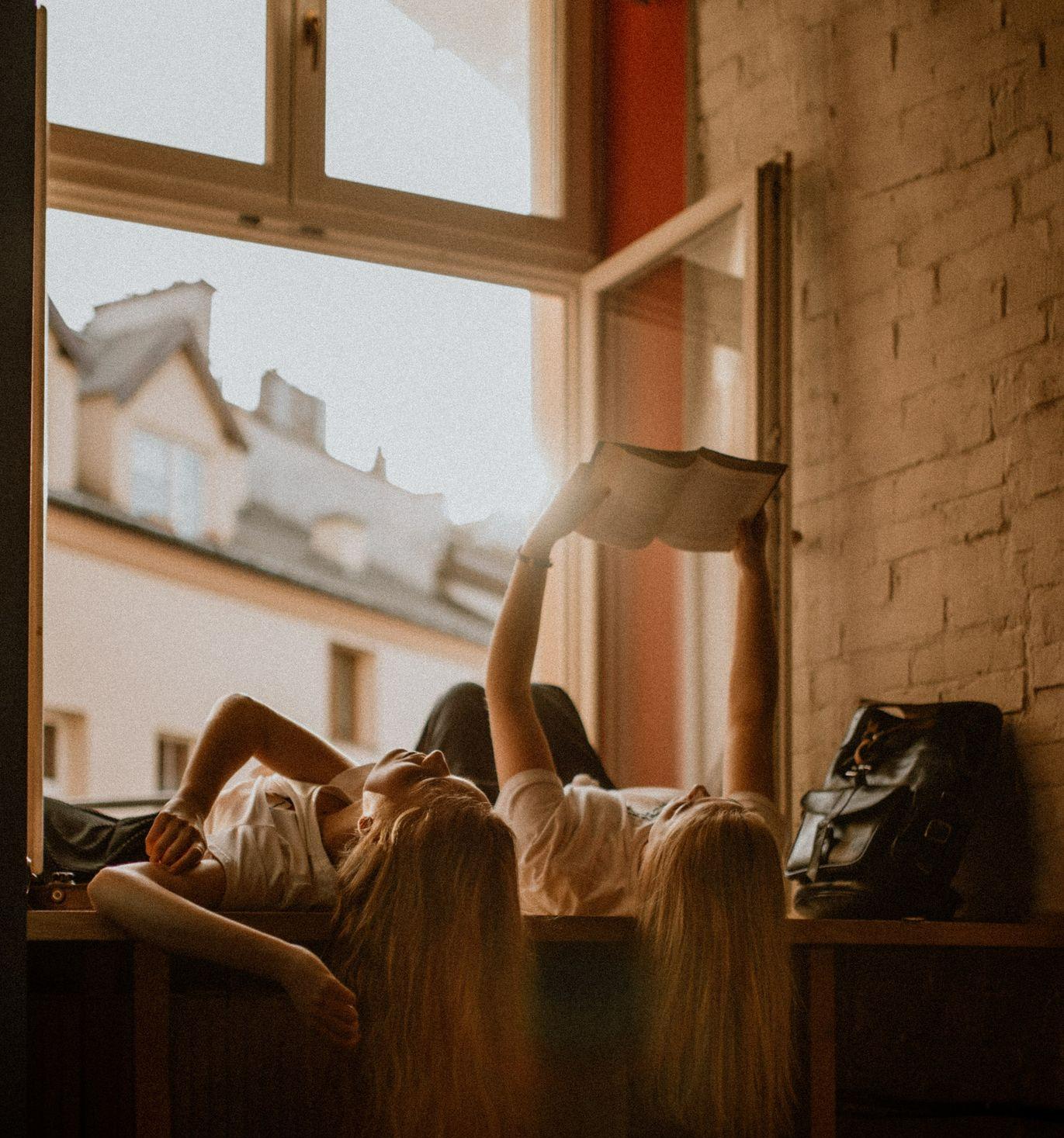 Coaching traject girls reading book while lying